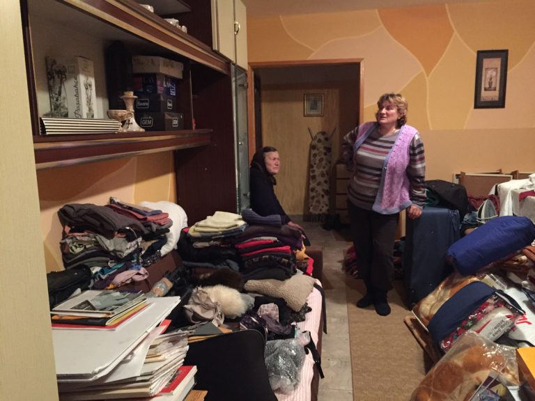a grandmother and a woman in a house with their belongings