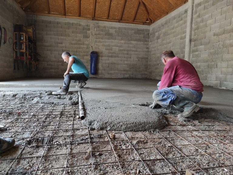 workers leveling concrete in a garage
