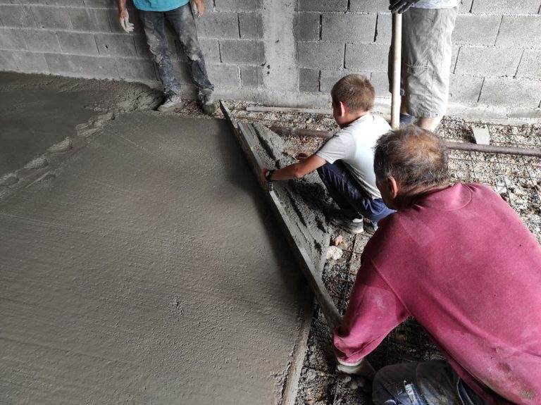 workers leveling concrete in a garage