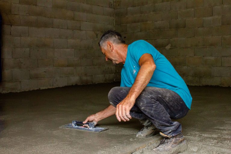 a man leveling concrete in a garage