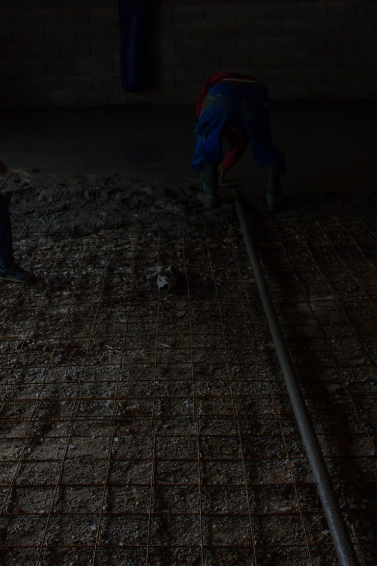 a man leveling concrete in a garage