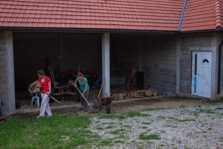 two women working in front of a garage