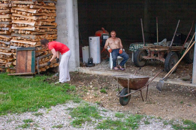 a man sitting in a garage and a woman working in front of a garage