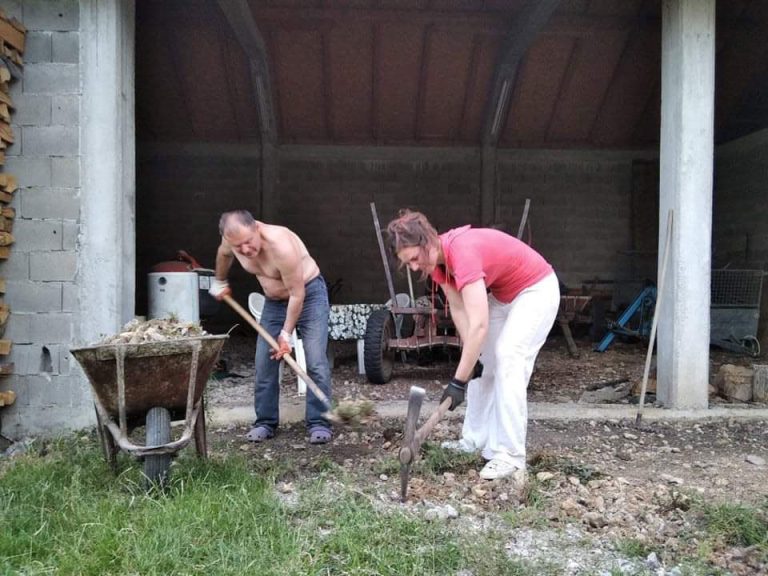 a man and a woman working in front of a garage