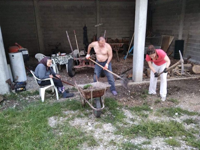 a grandmother, a man, and a woman working in front of a garage
