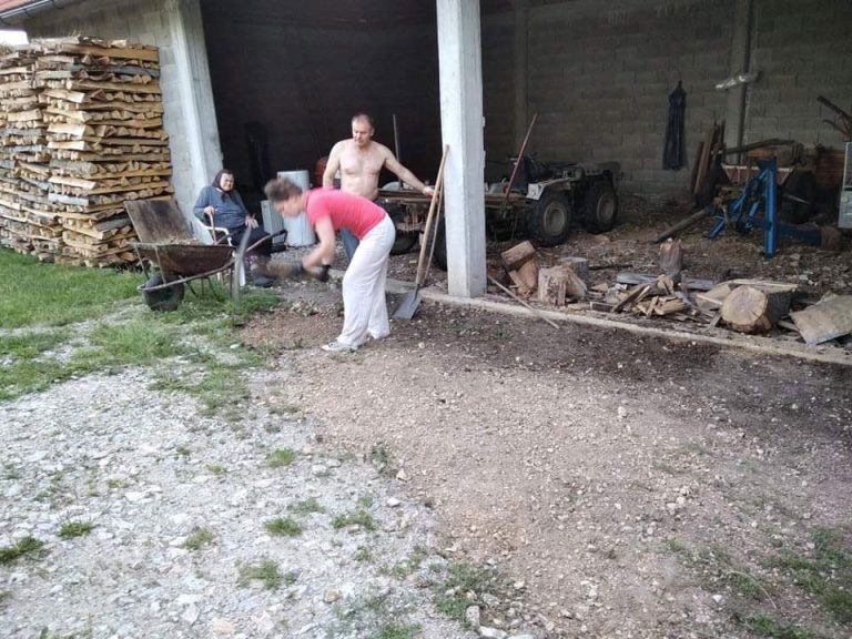 a grandmother, a man, and a woman working in front of a garage