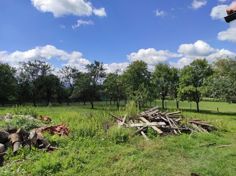 a pile of planks and a pile of logs in a field