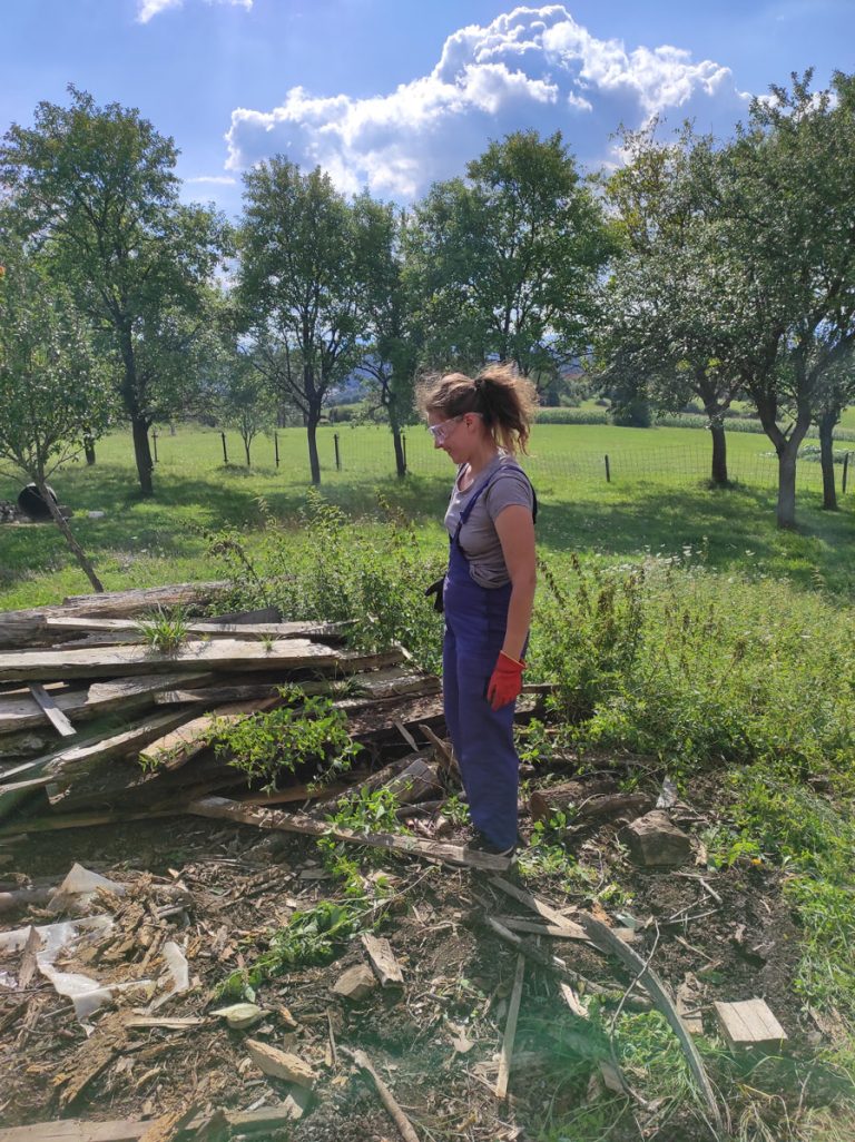 a girl with smiling face cleaning a backyard