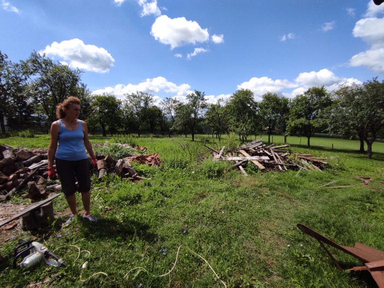 a woman cleaning a backyard