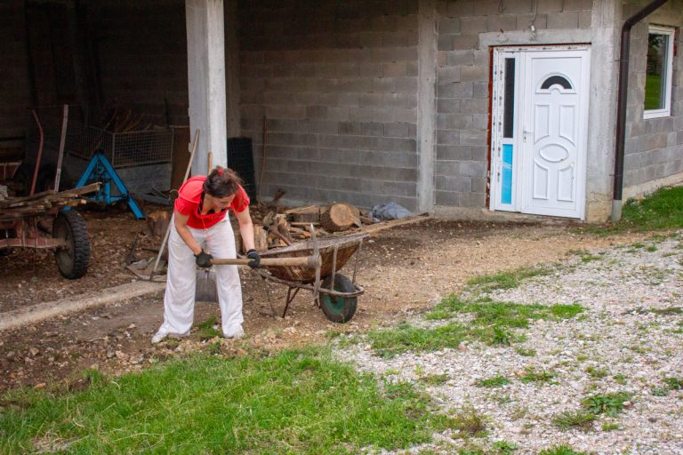 a woman with a pickaxe working in front of a garage