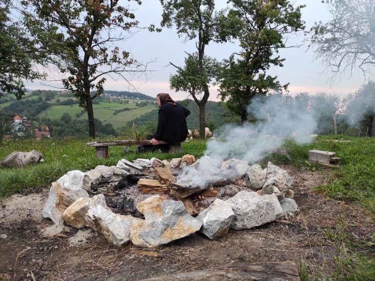 a grandma taking a rest next to the fire pit