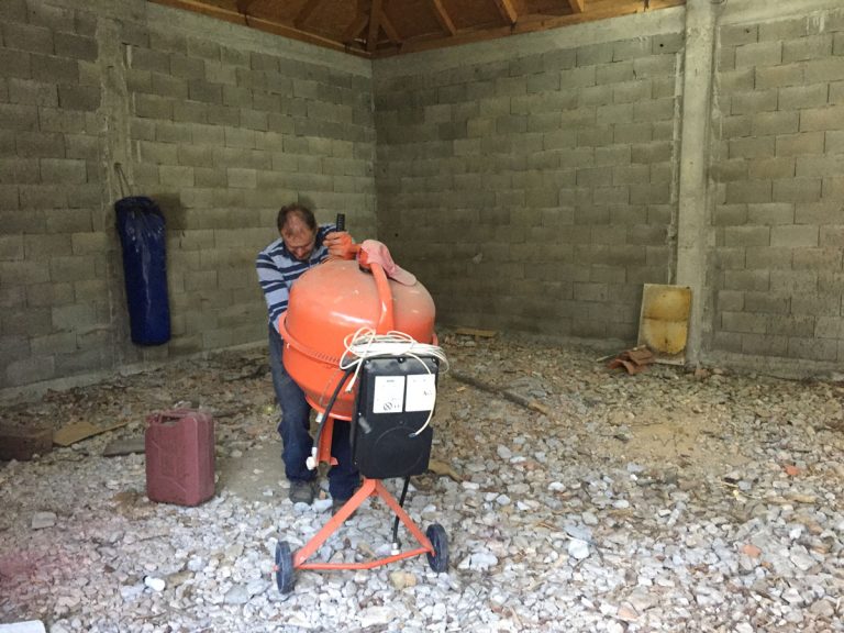 a man pulling a concrete mixer