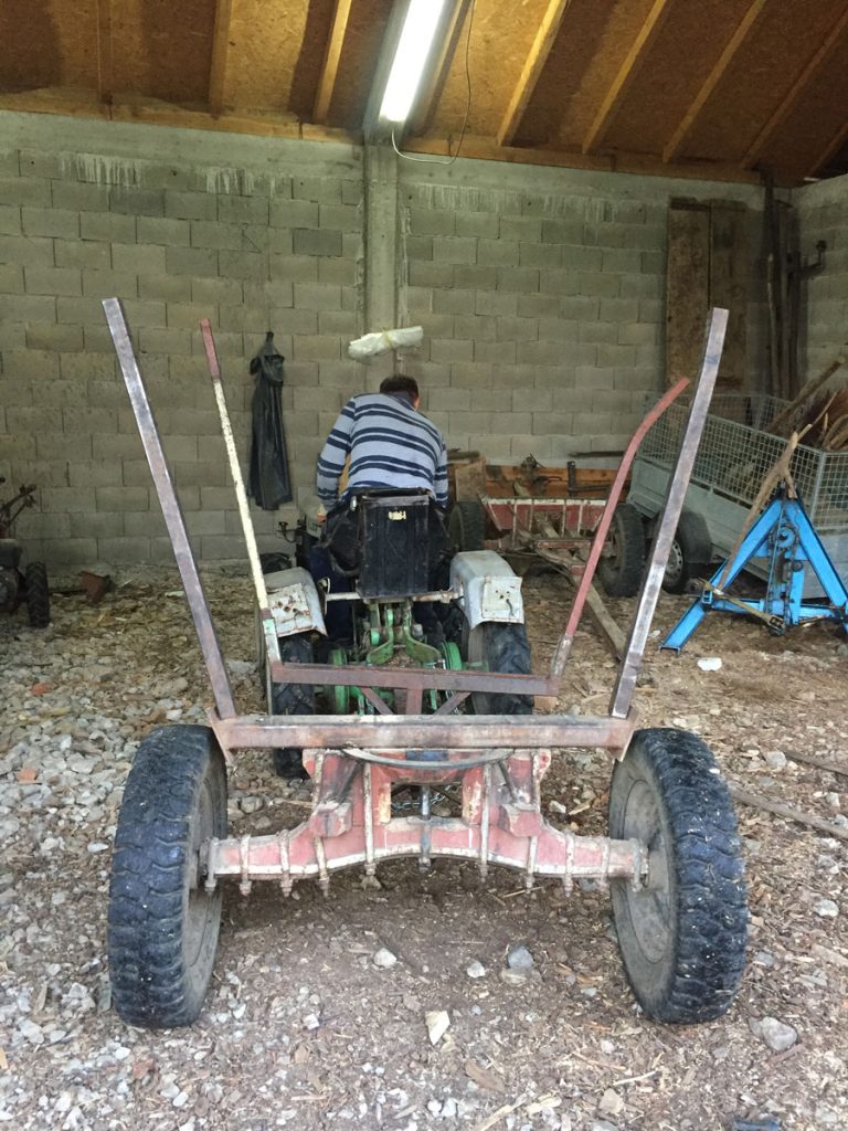 a man driving a small tractor with a carriage