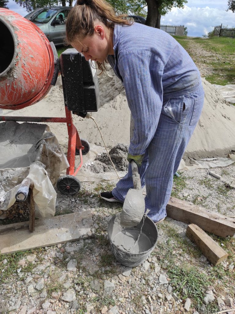 a girl pouring concrete in a bucket