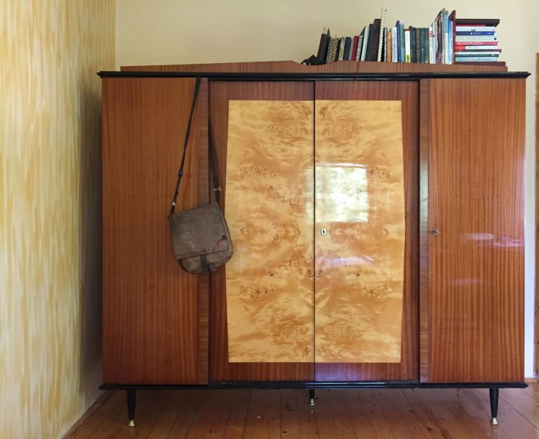 an old classic cabinet with books and a bag