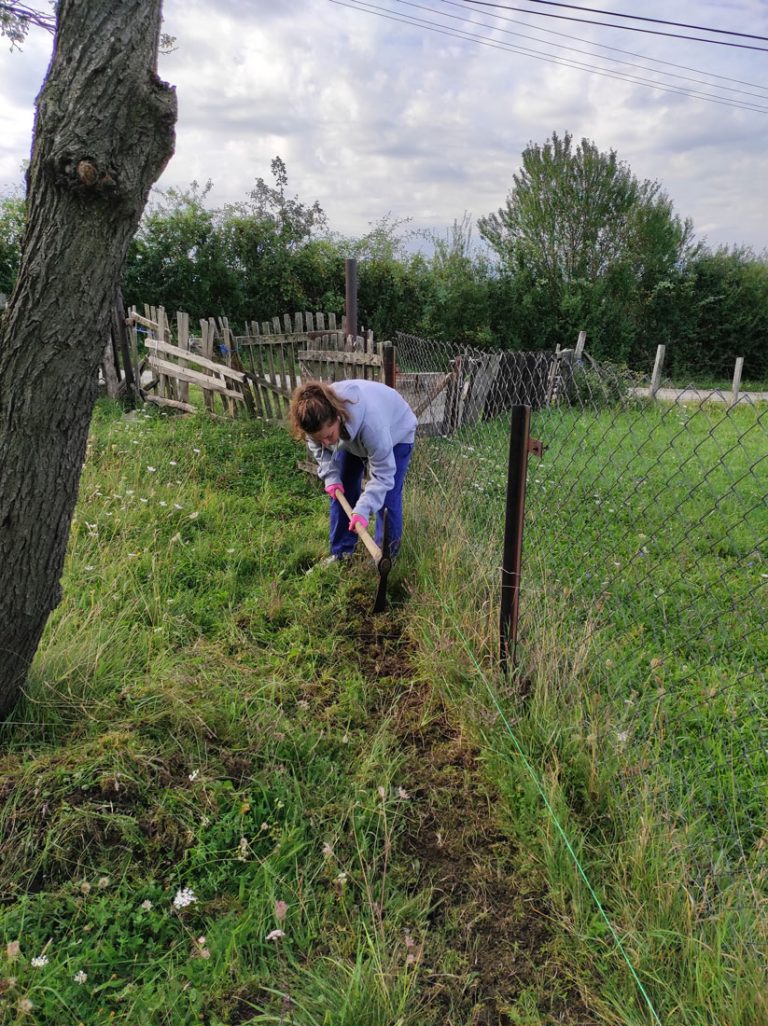 a girl digging dirt by the fence