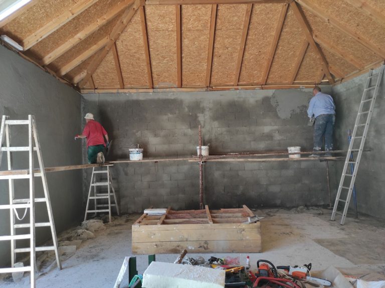 workers on scaffoldings mortaring the wall
