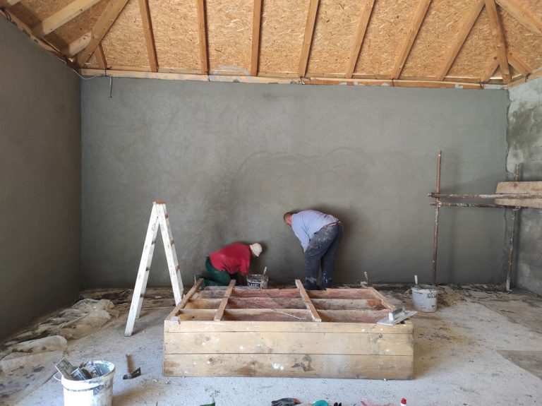 workers mortaring a wall in a garage