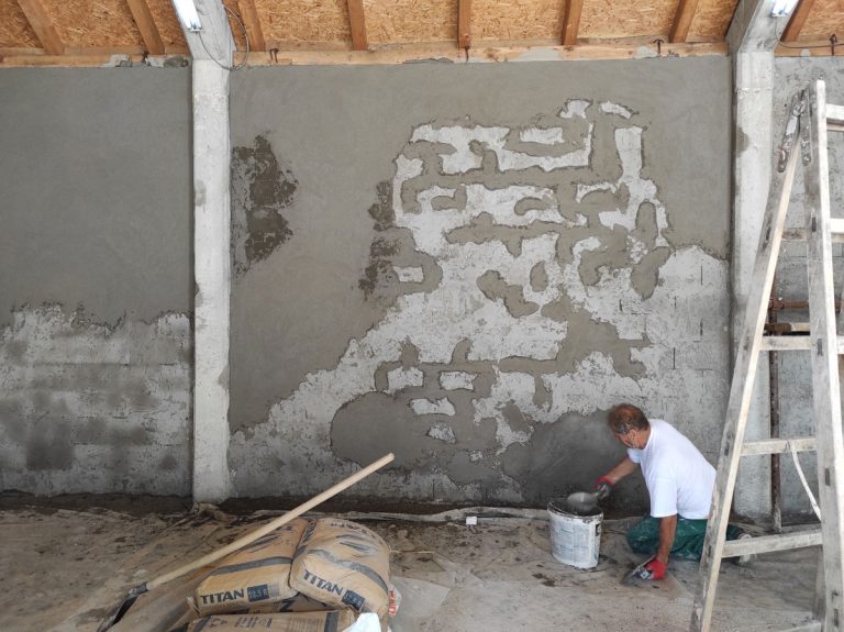 a worker mortaring a wall in a garage