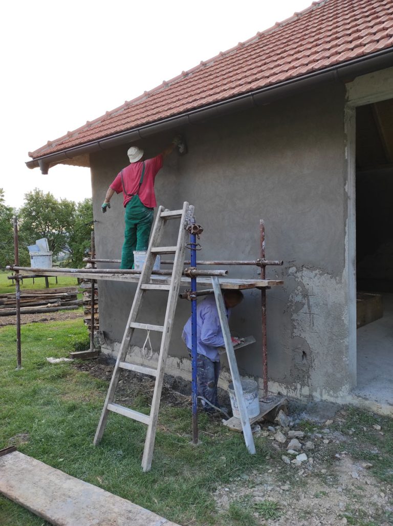 workers on scaffoldings mortaring the wall