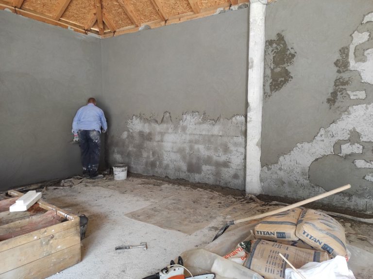 a worker mortaring a wall in a garage