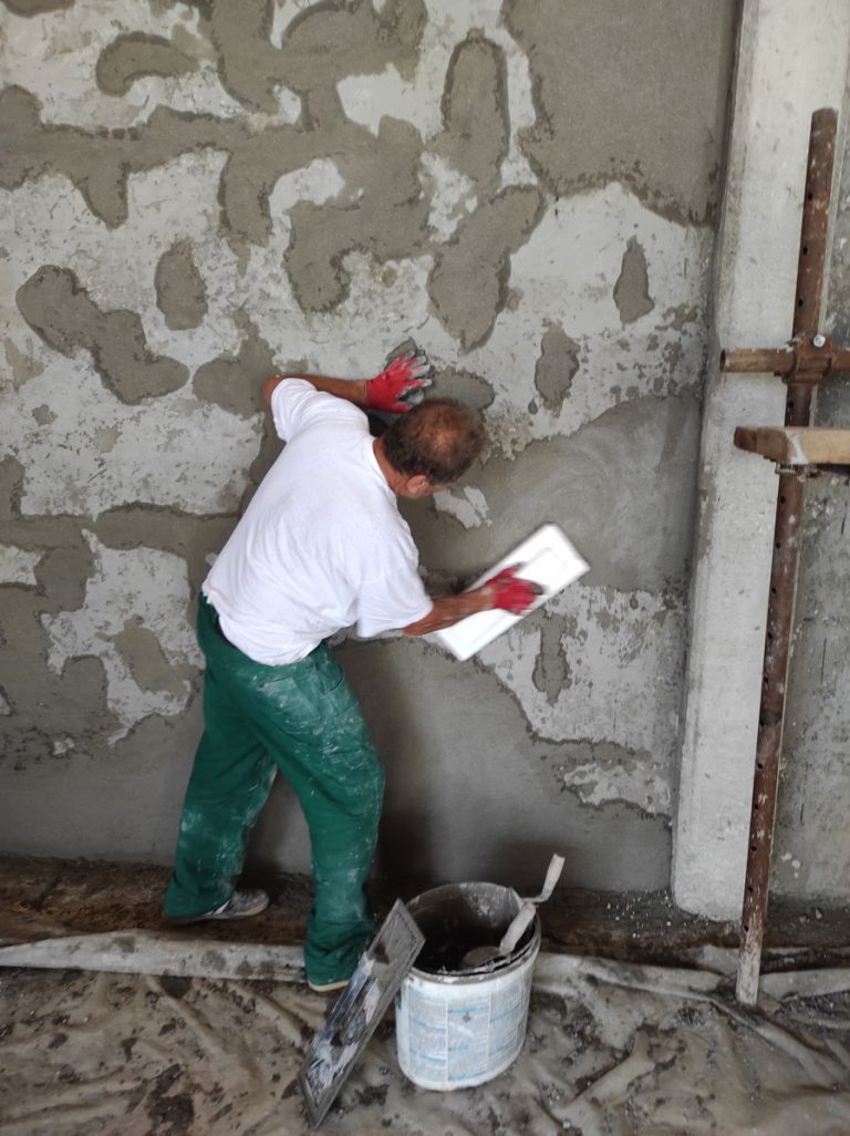 a worker mortaring a wall