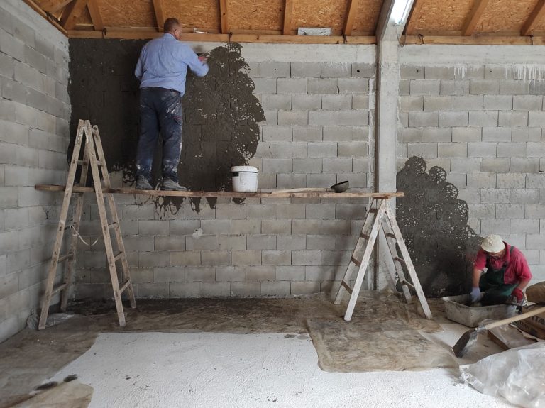 workers on scaffoldings mortaring the wall