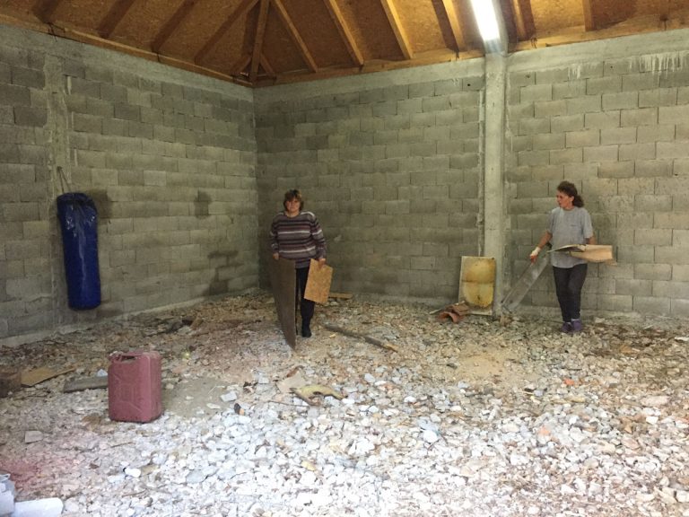 women in a garage moving stuff