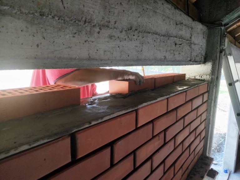 a worker building a brick wall