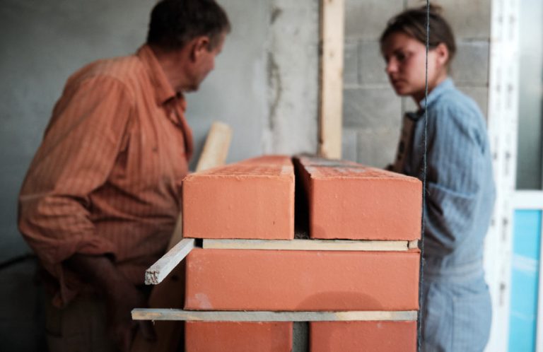workers building a brick wall