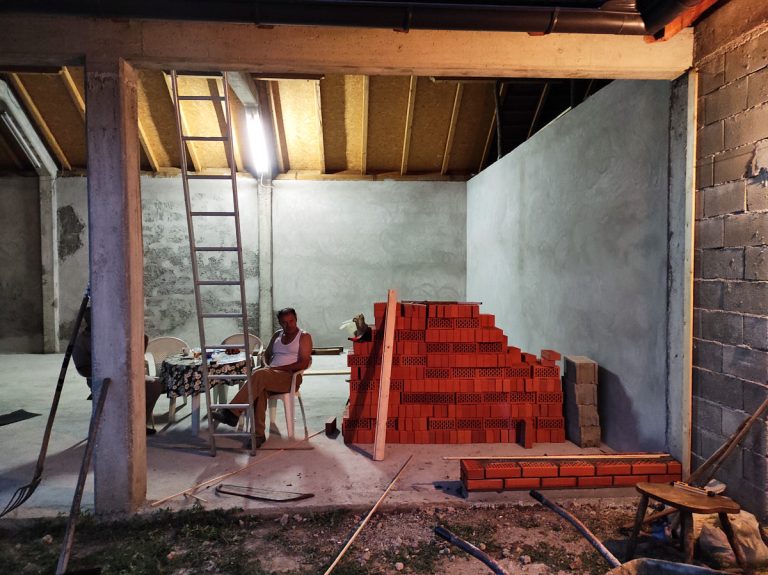 a worker taking a break after a day of work on building a brick wall