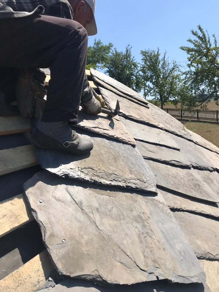 a worker installs new slate tiles