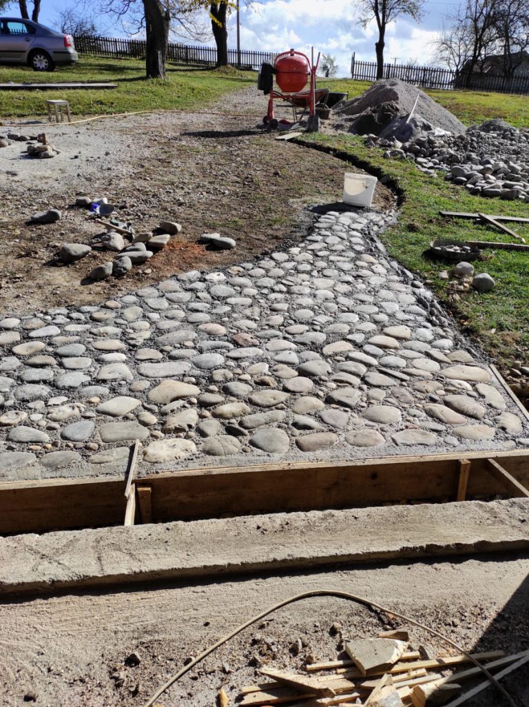 a cobblestone pavement in front of a garage