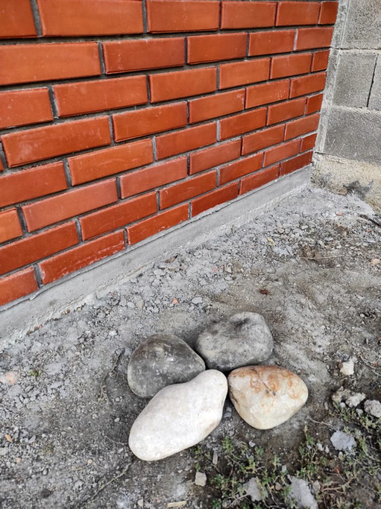 a cobblestone next to the brick wall