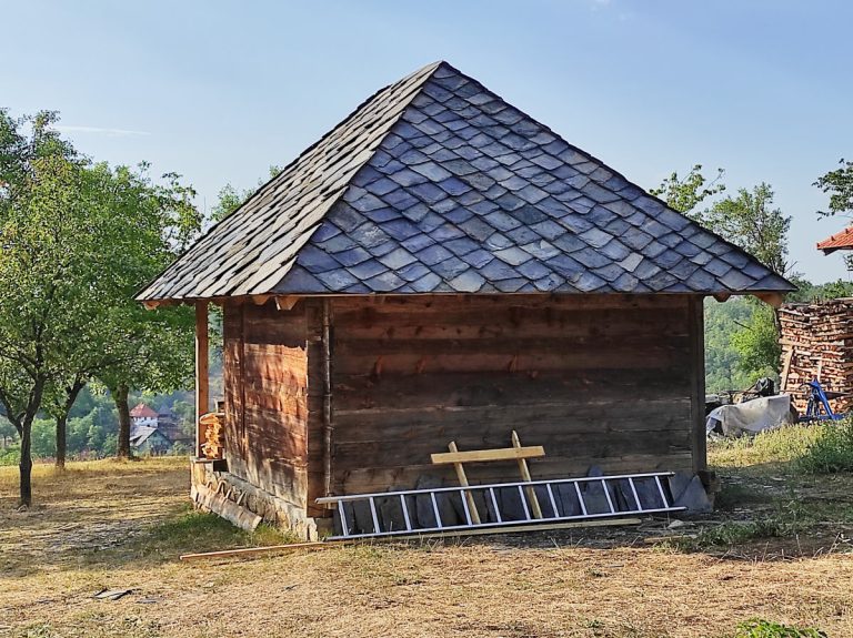 an old wooden cottage with a new stone roof tiles