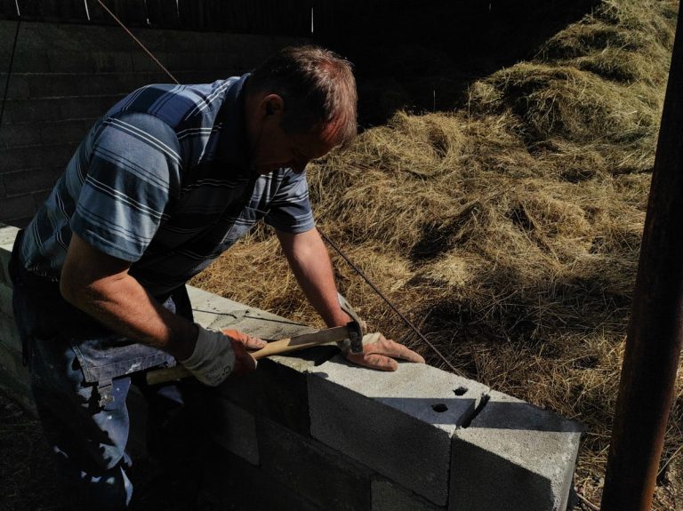 a worker building concrete blocks wall