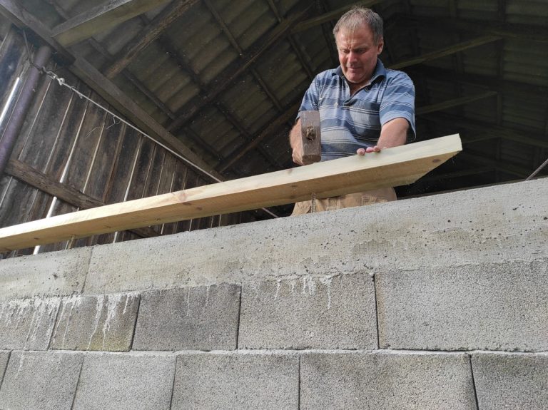 a worker building concrete blocks wall