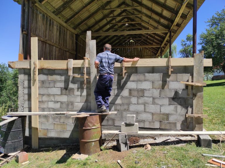 a worker building concrete blocks wall