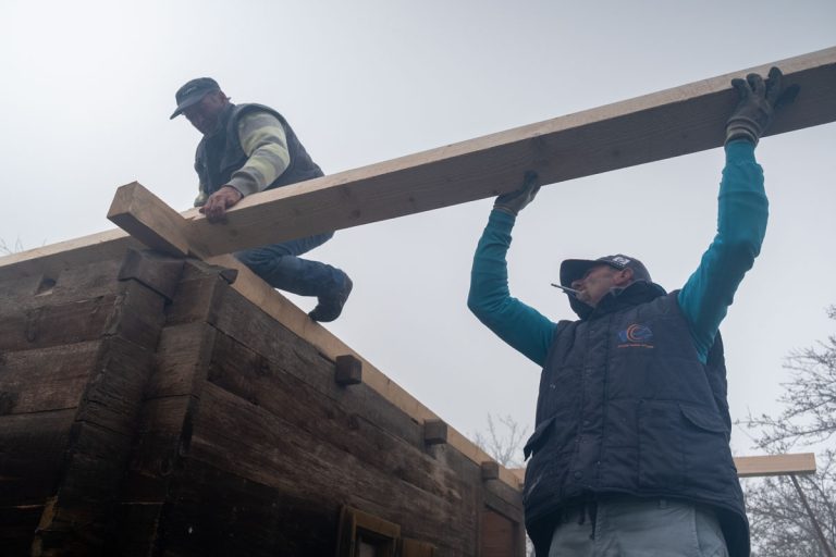 workers assembling a wooden cottage