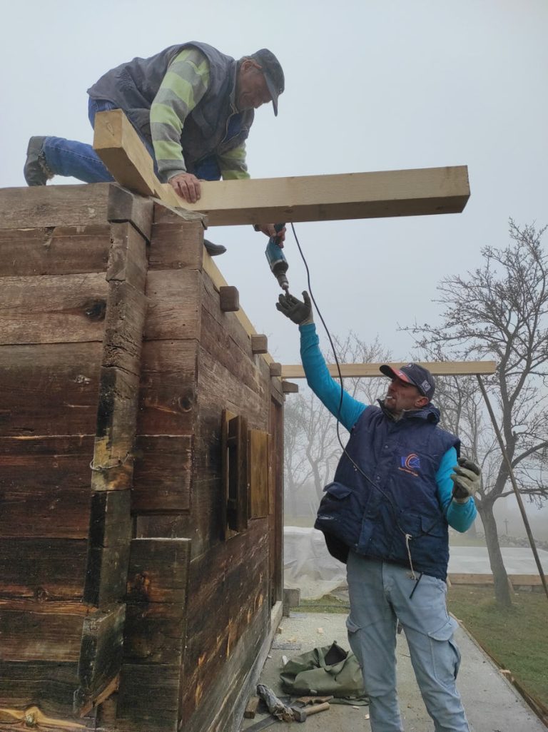 workers assembling a wooden cottage