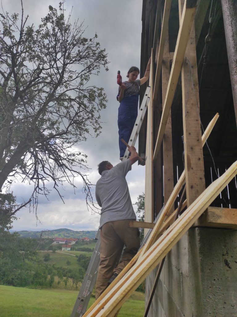 workers building a wooden wall on a hayloft