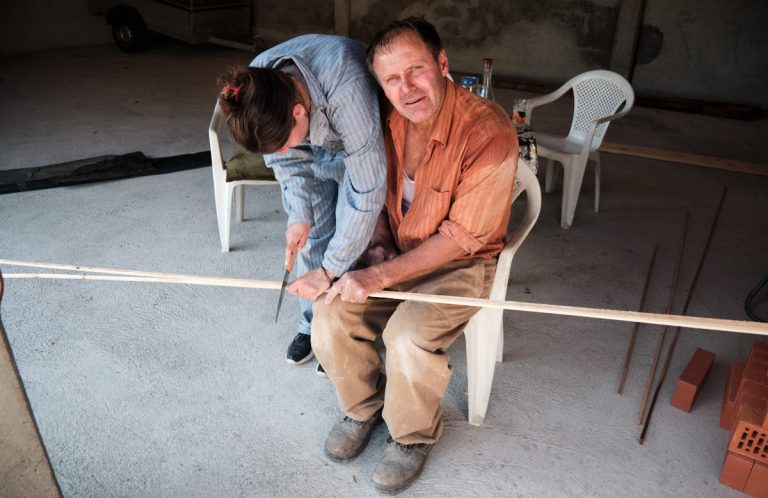 workers cut a wooden stick