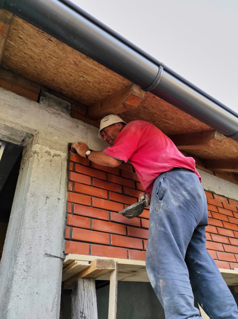 a worker building a brick wall