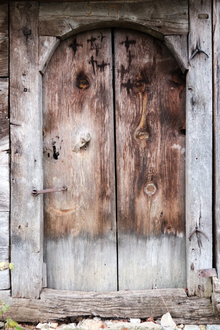 an old wooden cottage door with cross marks