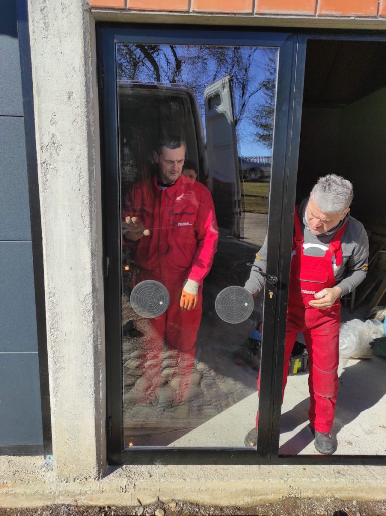 workers install glass into the door frame