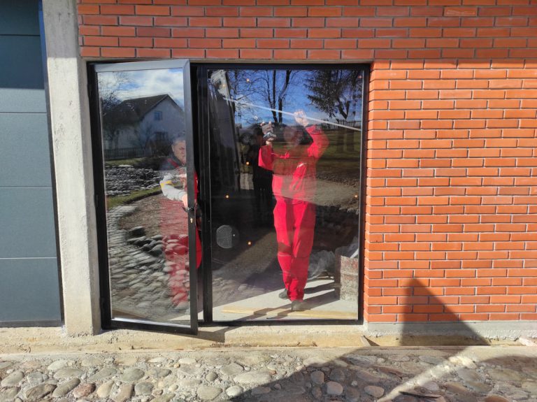 workers install glass into the door frame