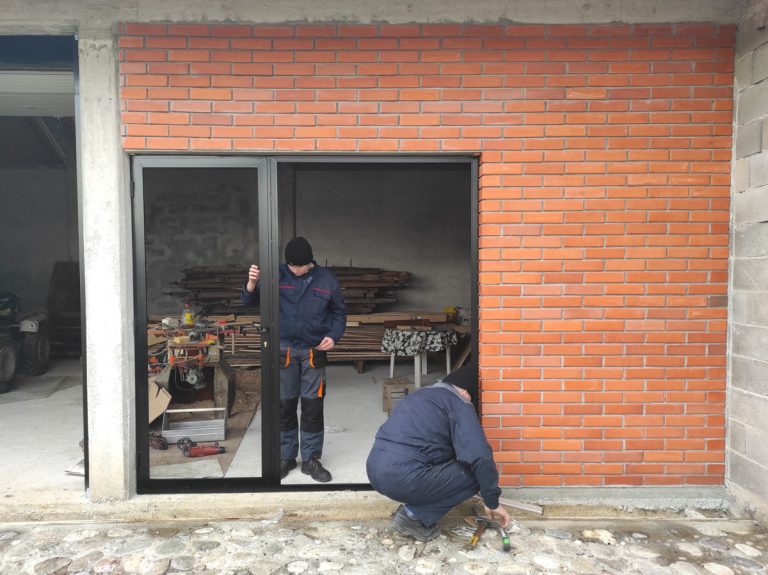 workers install glass into the door frame