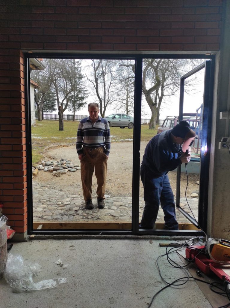 workers install glass into the door frame