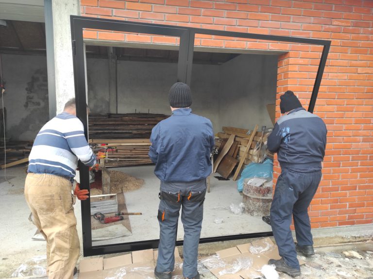 workers install glass into the door frame