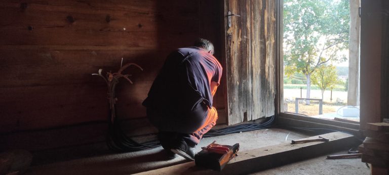 a worker install electricity in a woode cottage